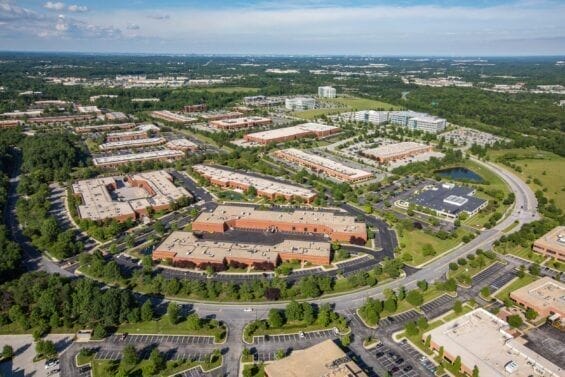 An aerial view of an office complex surrounded by trees and paved streets.