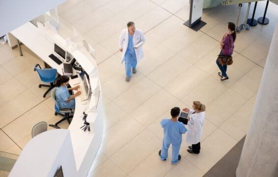 An aerial view of doctors and nurses walking through a hospital foyer.