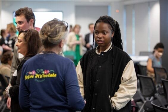A young student listens while in conversation with an older woman.